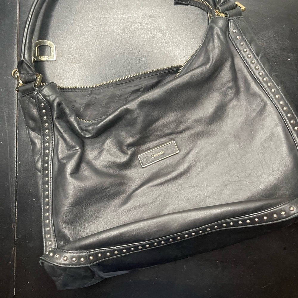 DKNY black leather hobo bag with stud detailing.